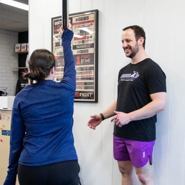 Woman exercising with a barbell bar with coach