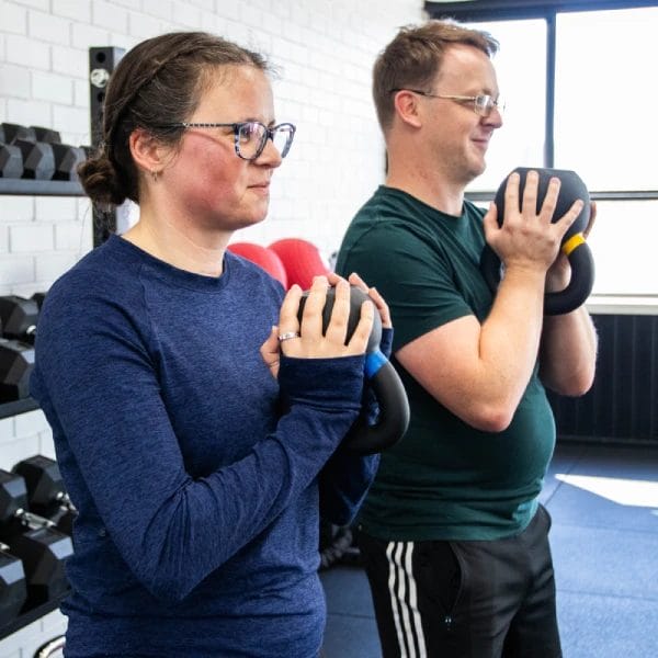 Woman and man lifting kettlebell